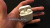 Holding Apple AirPods 2nd generation in hand