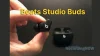 Holding Beats Studio Buds wireless earbuds in hand