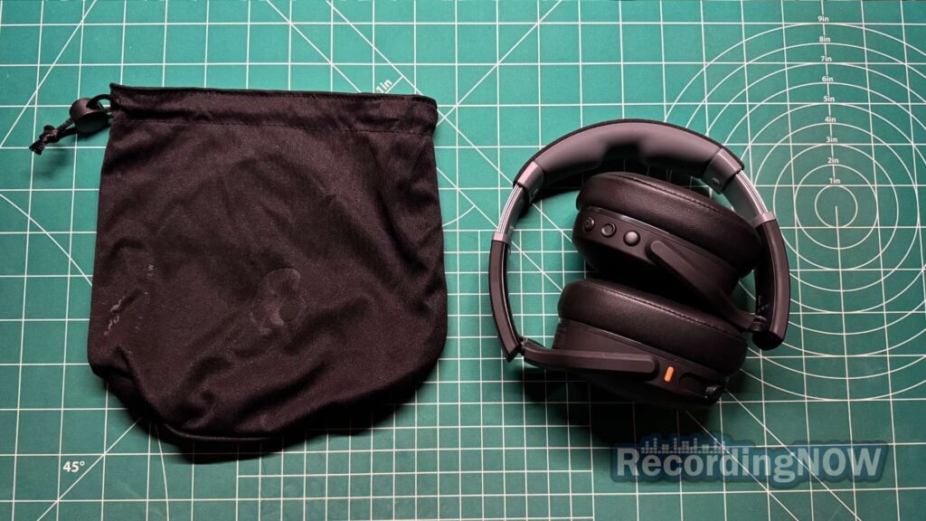 Skullcandy Crusher Evo headphones folded and collapsed next to included soft shell case bag