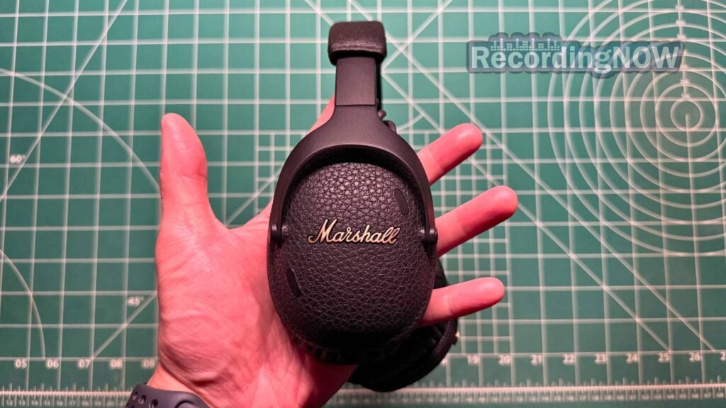 Holding Marshall Monitor III ANC headphones in hand