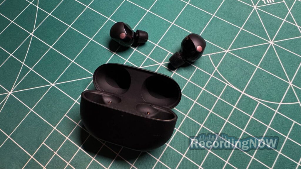Sony WF-1000XM5 wireless noise cancelling earbuds next to charging case