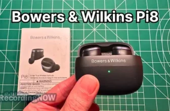 Holding Bowers & Wilkins Pi8 wireless noise cancelling earbuds in hand