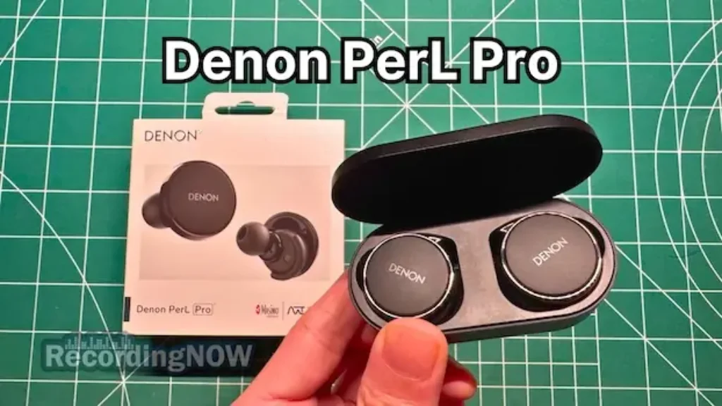 Holding Denon PerL Pro wireless noise cancelling earbuds in hand