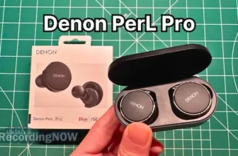 Holding Denon PerL Pro wireless noise cancelling earbuds in hand
