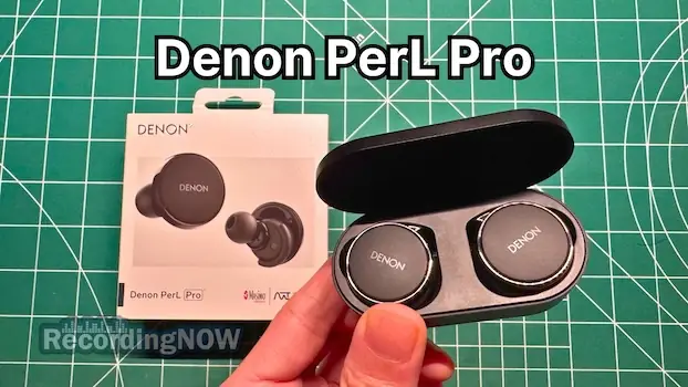 Holding Denon PerL Pro wireless noise cancelling earbuds in hand