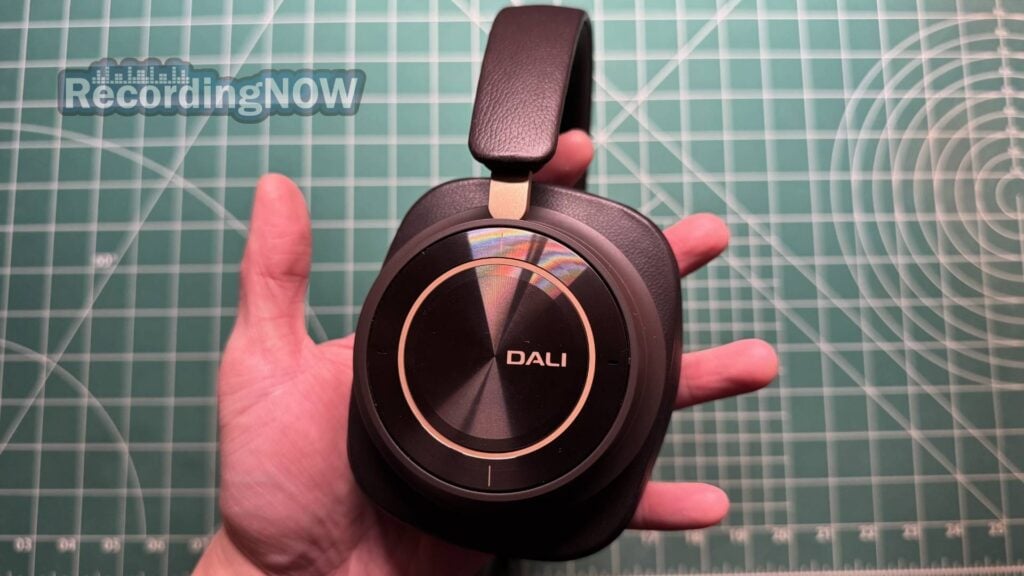 Holding Dali IO-12 headphones in hand