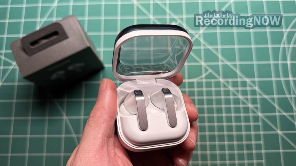 Holding Samsung Galaxy Buds4 Pro inside charging case in hand