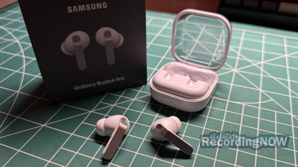 Close up of Samsung Galaxy Buds 4 Pro earbuds next to charging case and original box on desk