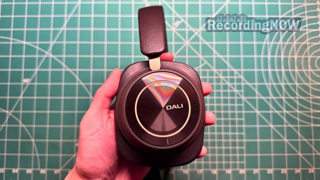 Holding Dali IO-12 wireless headphones in hand