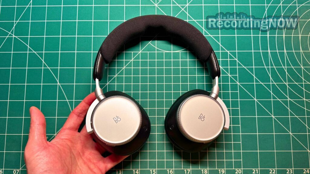 Holding Bang and Olufsen Beoplay H100 headphones in hand