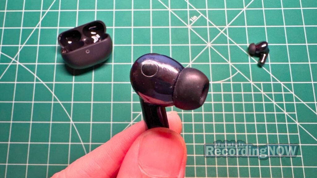 Holding Huawei FreeBuds Pro 5 earbuds with silicone eartips in hand