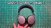 Holding Sennheiser Momentum 5 headphones in hand