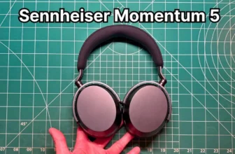 Holding Sennheiser Momentum 5 headphones in hand