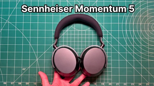 Holding Sennheiser Momentum 5 headphones in hand