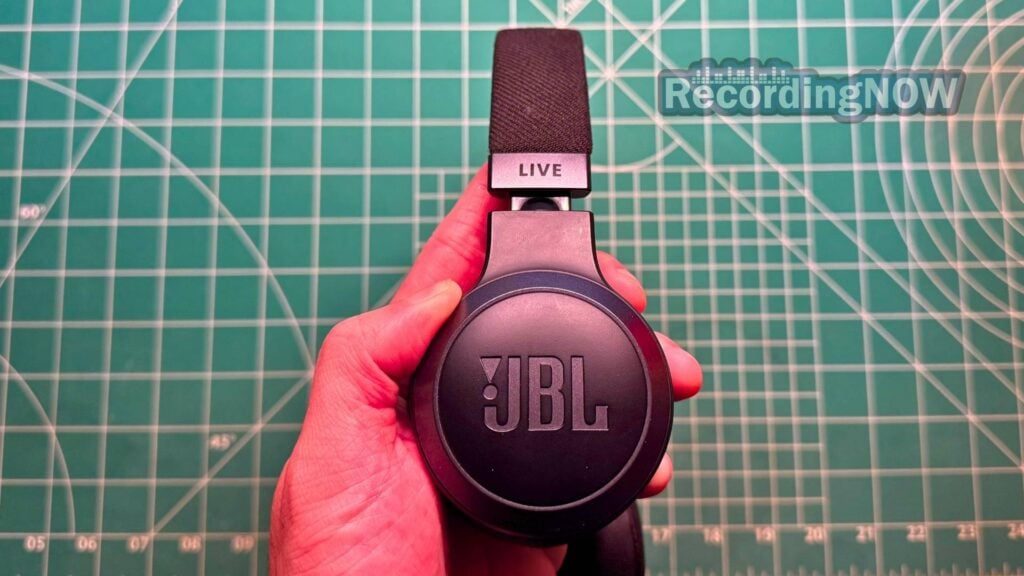 Holding JBL 670NC on-ear wireless ANC headphones in hand