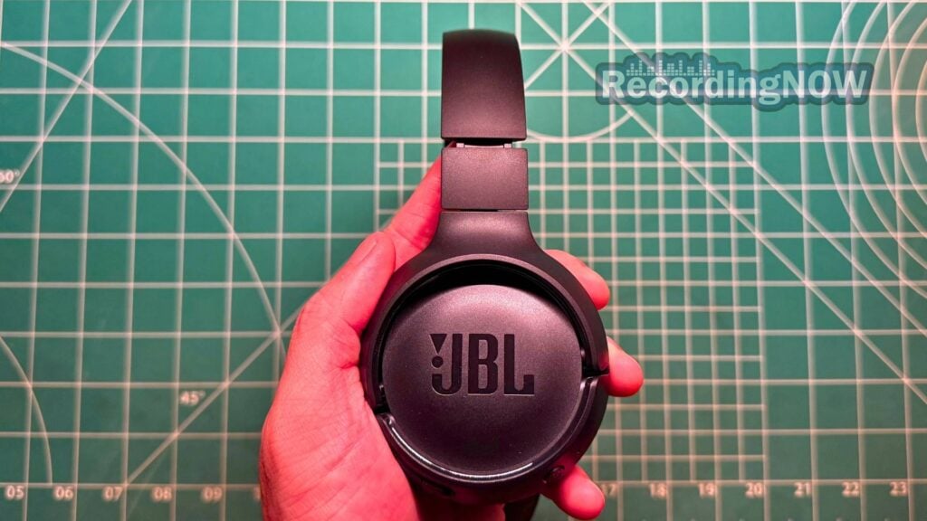 Holding JBL Tune 510BT headphones in hand