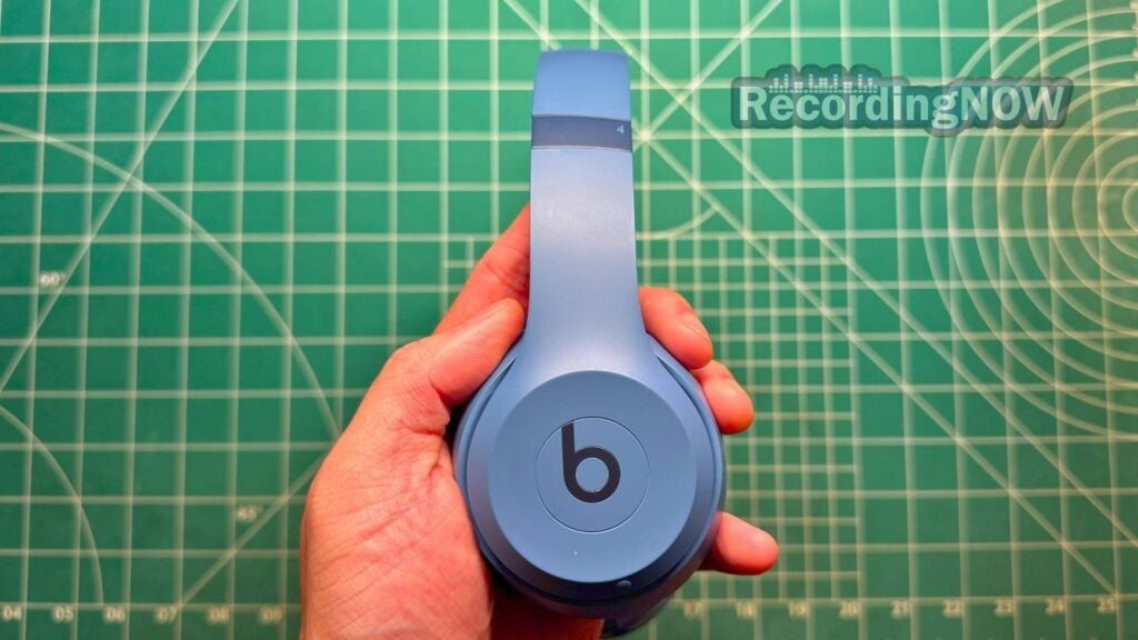 Holding Beats Solo 4 headphones in hand