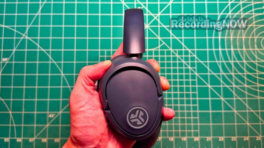 Holding JLab JBuds Lux ANC wireless noise cancelling headphones in hand