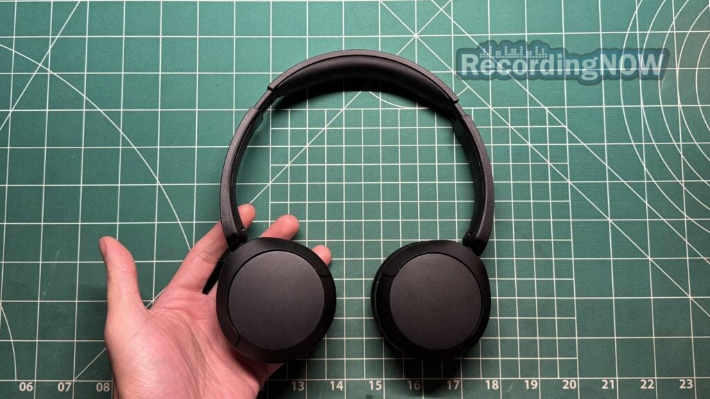 Holding Sony WH-CH520 headphones in hand