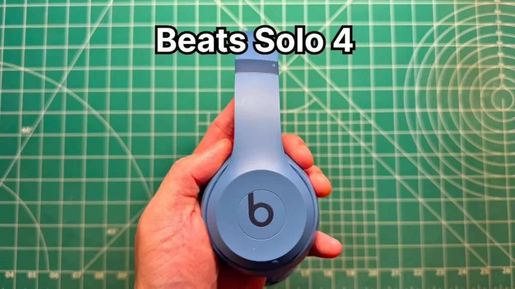 Holding Beats Solo 4 wireless on-ear headphones in blue in hand