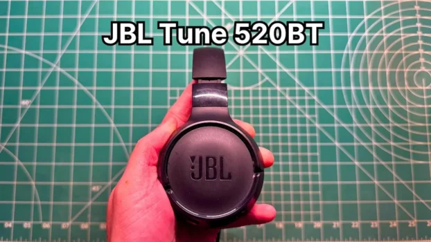 Holding JBL Tune 520BT wireless on-ear headphones in hand