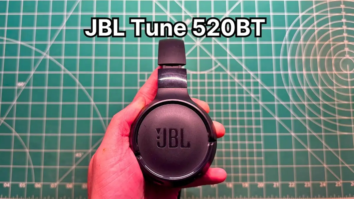 Holding JBL Tune 520BT wireless on-ear headphones in hand