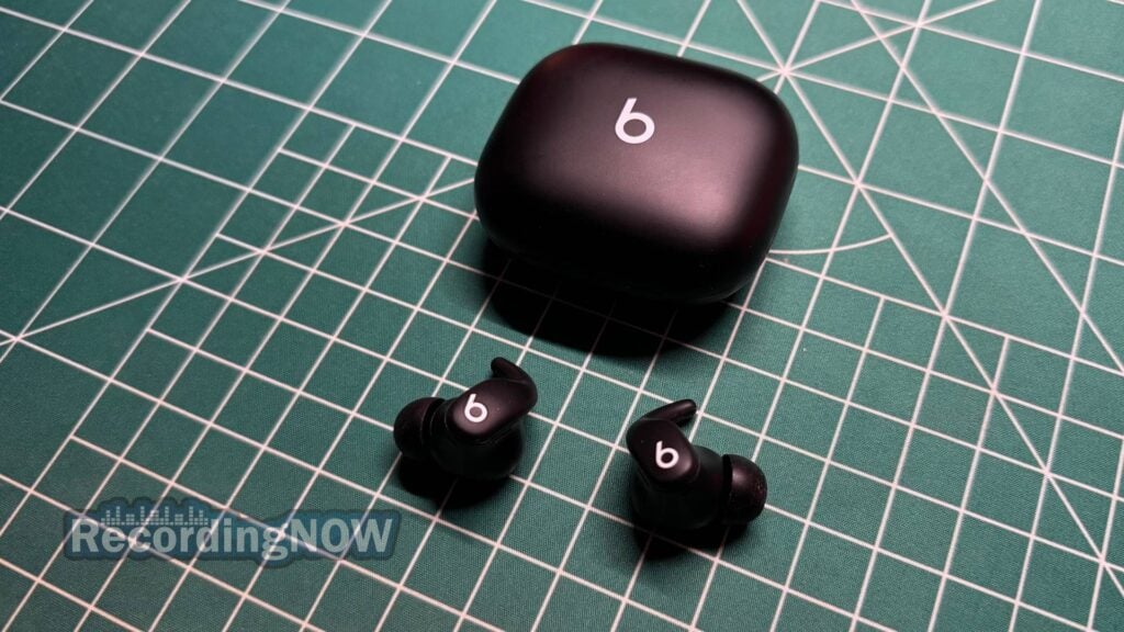Beats Powerbeats Fit earbuds next to charging case