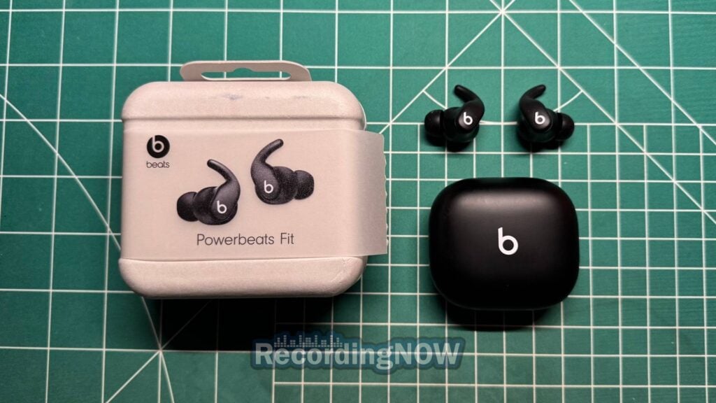 Beats Powerbeats Fit in black next to original box packaging