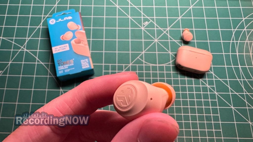 Holding JLab Go Air Pop+ wireless noise cancelling earbuds in hand