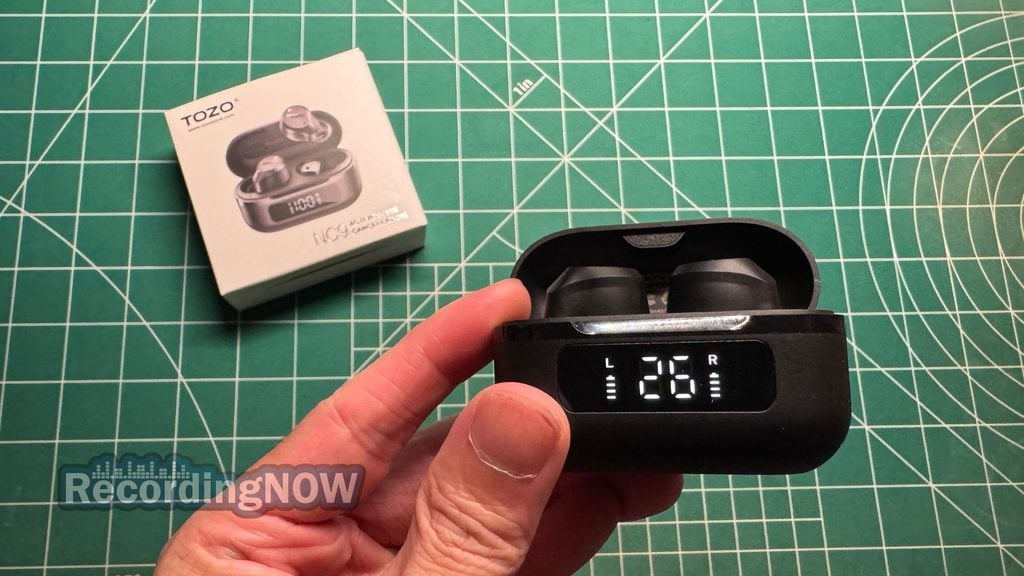 Holding TOZO NC9 wireless noise cancelling earbuds inside charging case