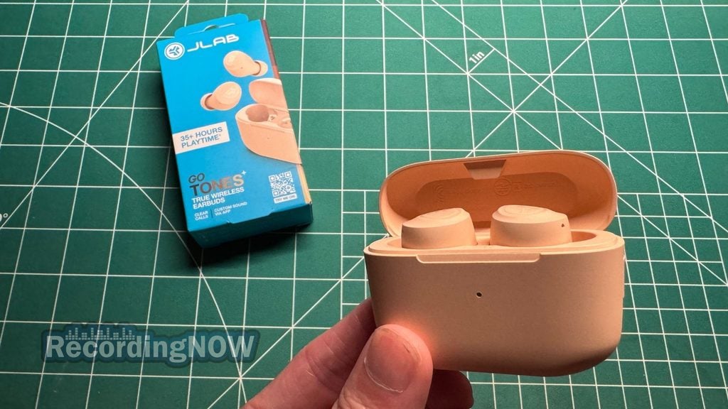 Holding JLab Go Air Pop+ wireless noise cancelling earbuds inside charging case