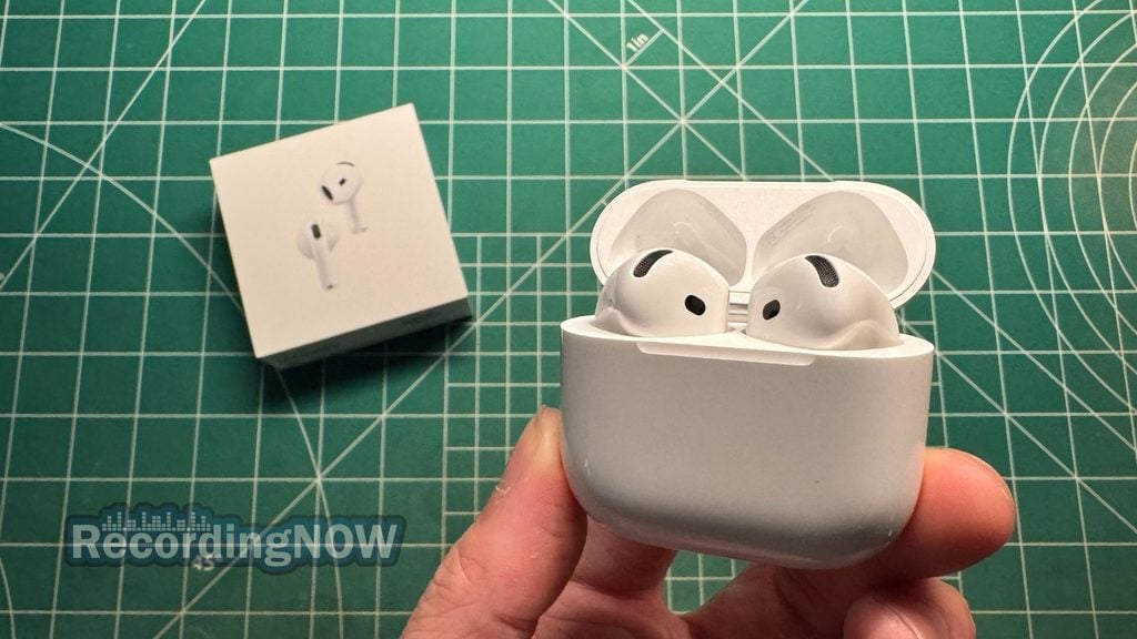 Holding Apple AirPods 5 noise cancelling earbuds inside wireless charging case