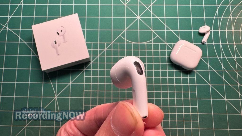 Holding Apple AirPods 5 wireless noise cancelling earbuds in hand