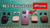 Apple iPhone 15 Pro next to AirPods Pro 3 and several wireless noise cancelling earbuds