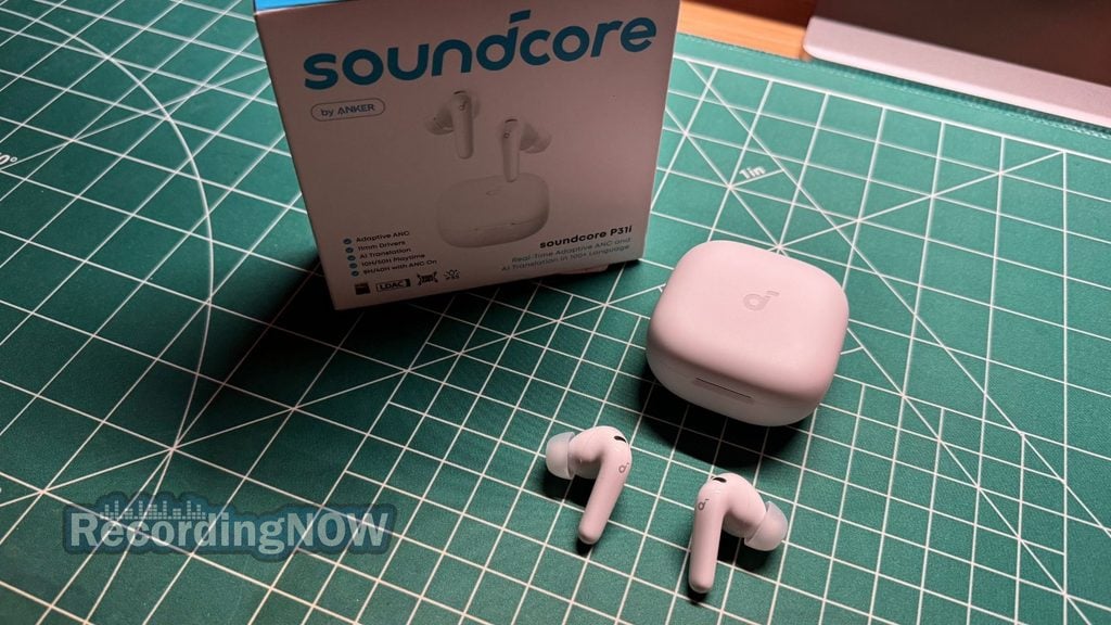 Soundcore P31i earbuds and charging case next to original box packaging