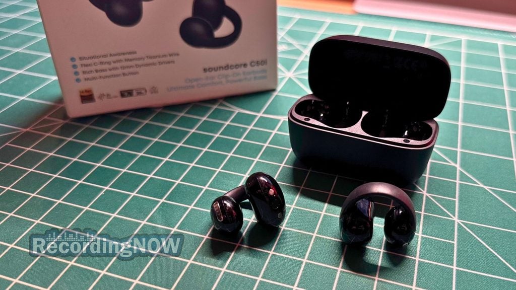 Soundcore C50i open ear clip on earbuds and charging case next to original box packaging