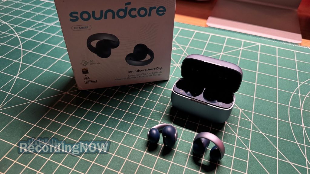 Soundcore AeroClip open ear clip on earbuds and charging case next to original box packaging