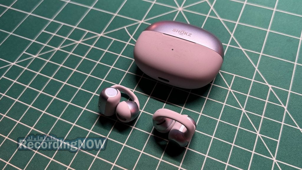 SHOKZ OpenDots 2 clip on earbuds next to charging case on desk