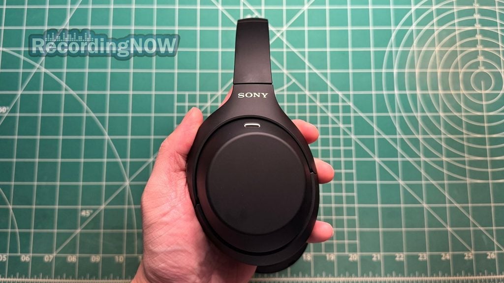 Holding earcup of Sony WH-1000XM4C headphones in hand
