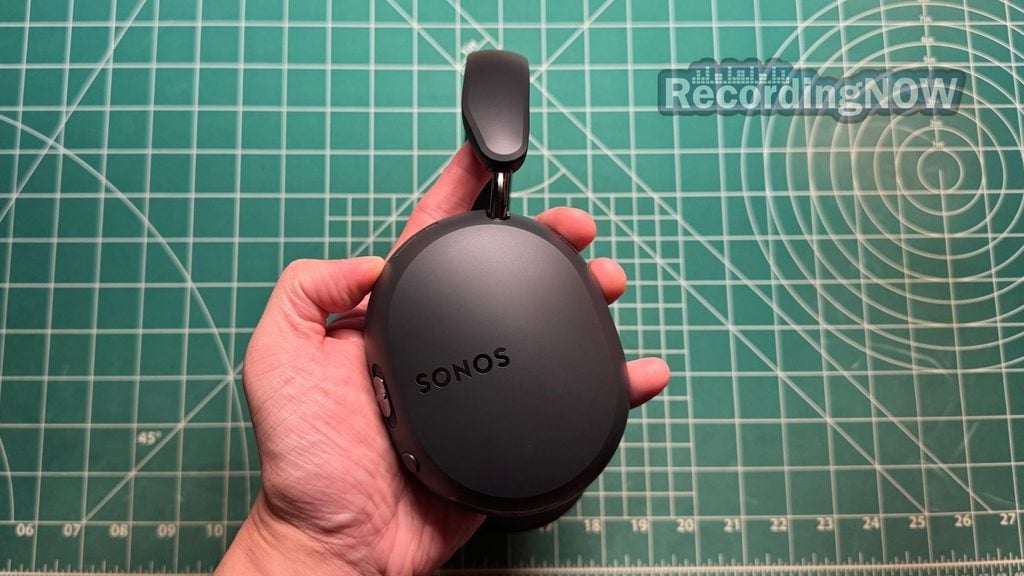 Holding earcup of Sonos Ace Ultra headphones in hand