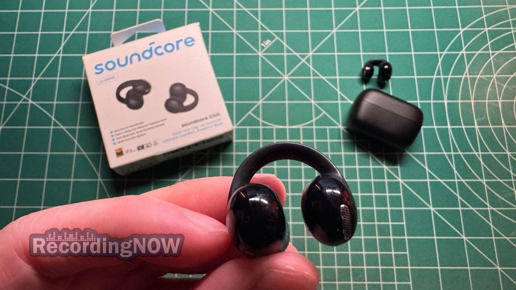 Holding Anker Soundcore C50i wireless clip on earbud in hand