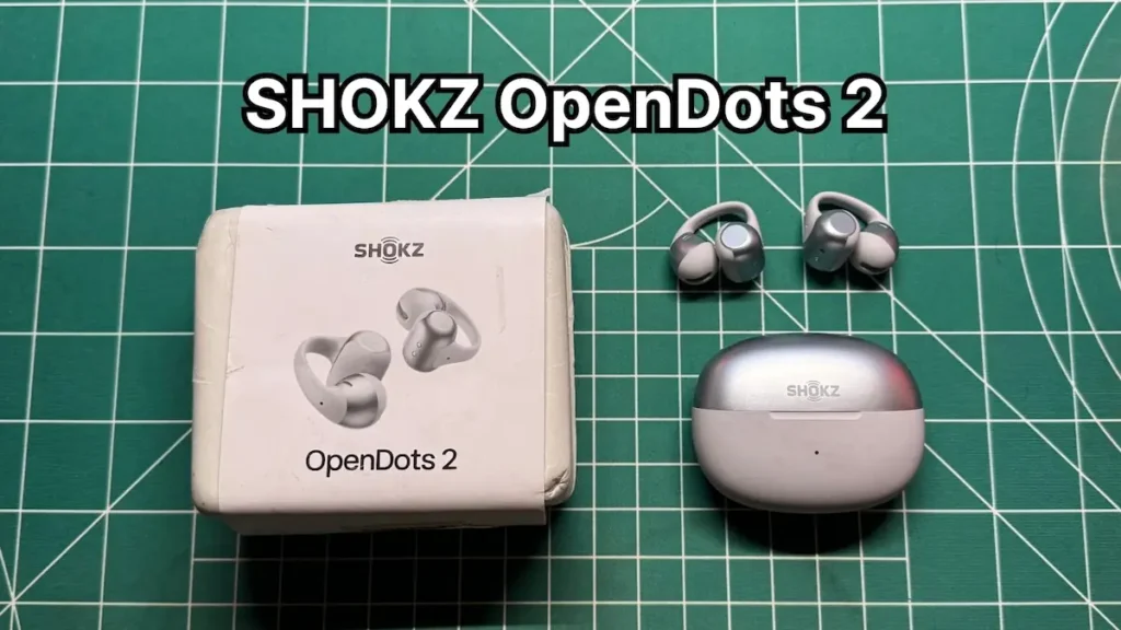 SHOKZ OpenDots 2 clip on open ear earbuds next to charging case and box