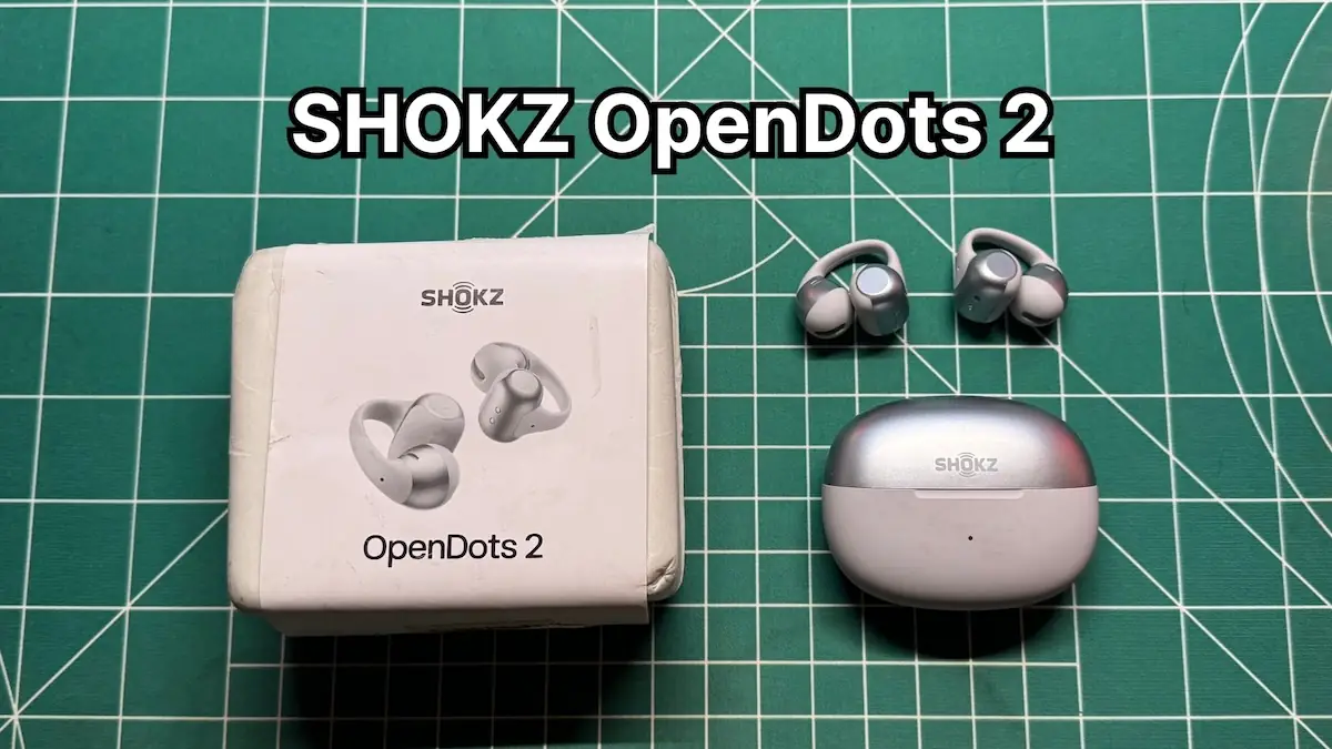 SHOKZ OpenDots 2 clip on open ear earbuds next to charging case and box